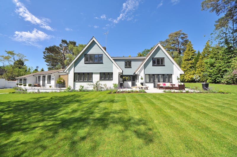Modern home with a large green lawn under a clear blue sky
